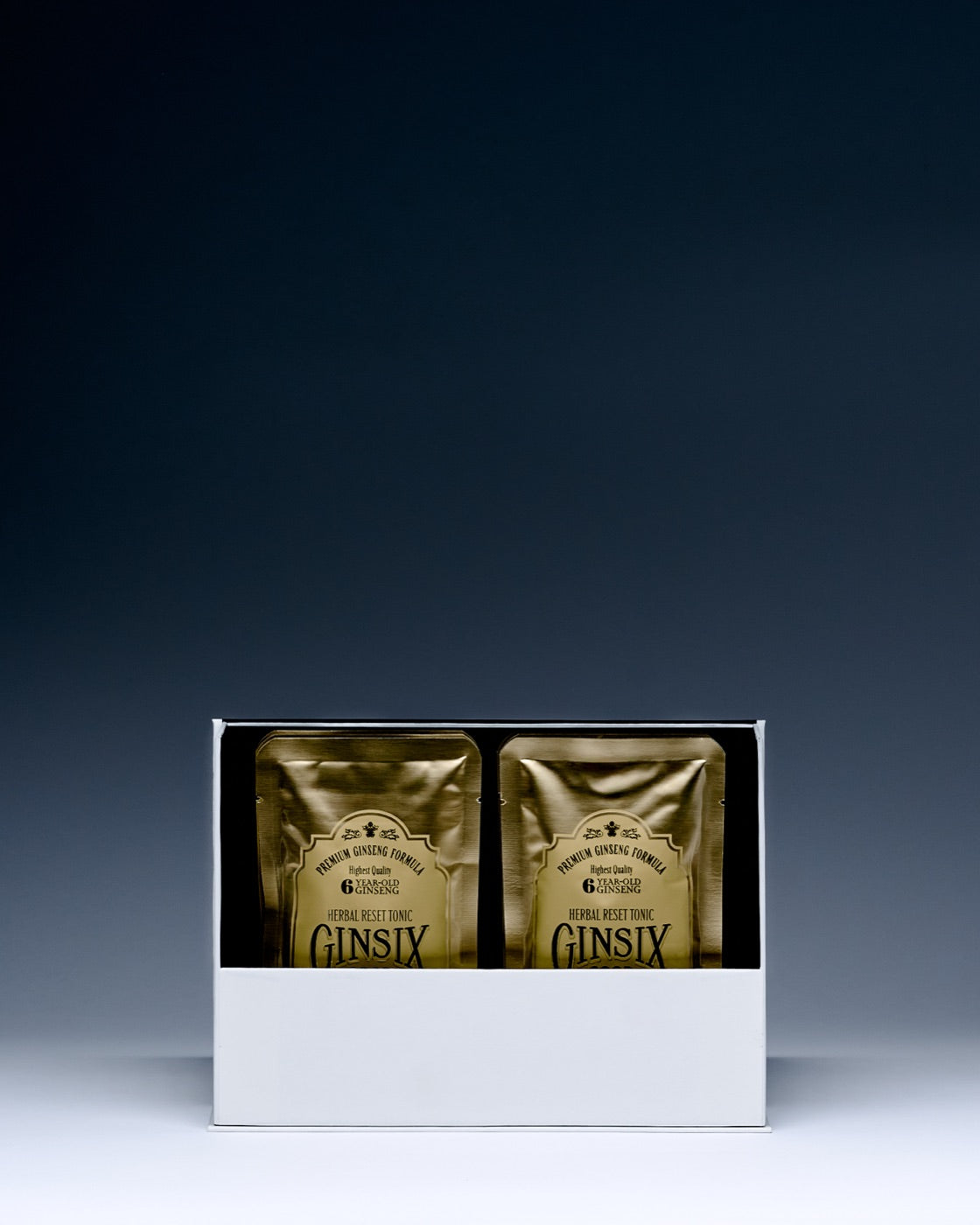 An open GINSIX box showing two gold 80mL herbal tonic pouches